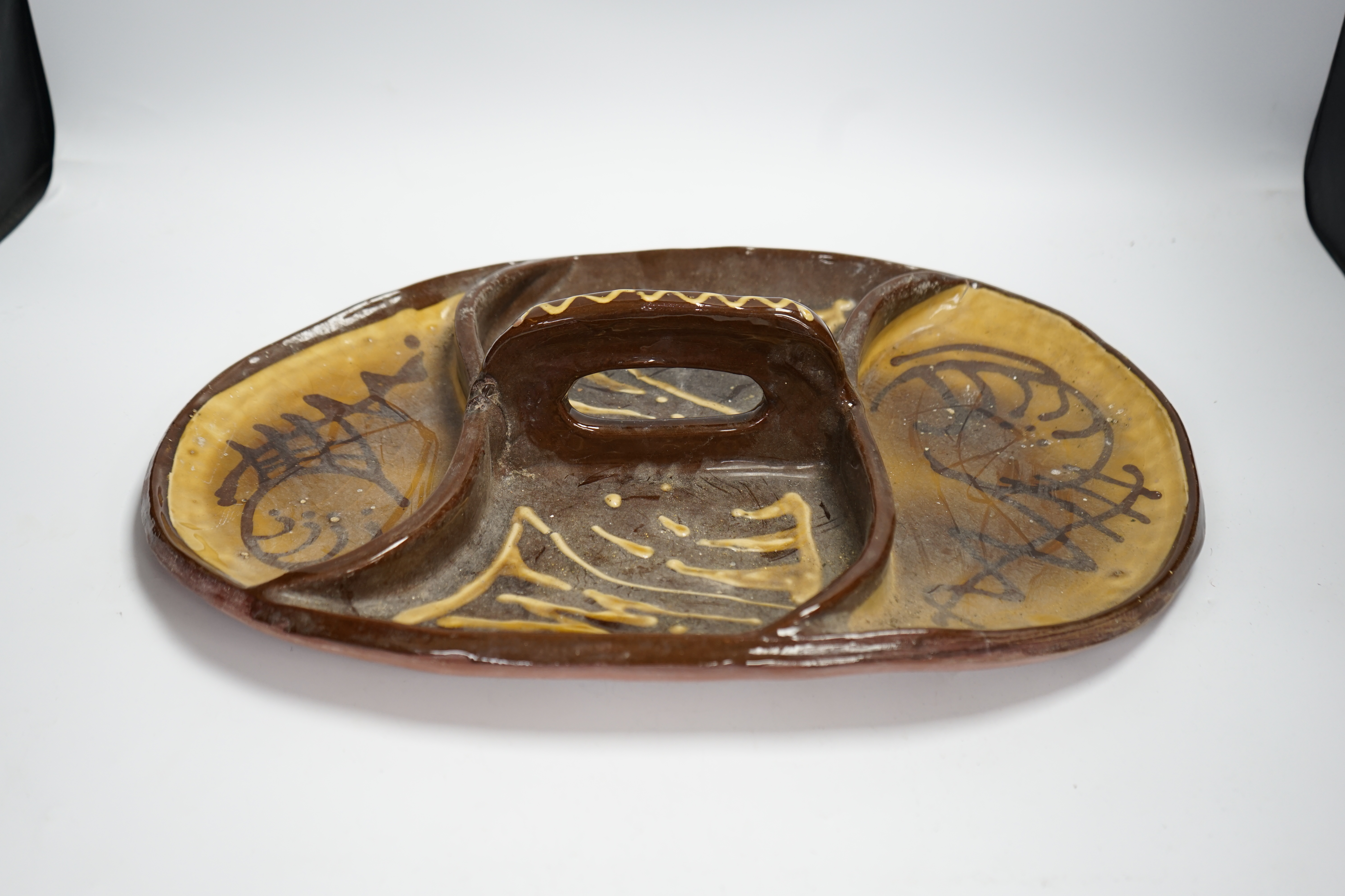 A set of nine studio pottery plates together with a slipware dish, 46cm long